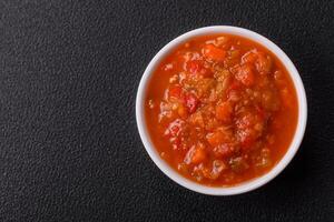 Red hot or spicy sauce with chili peppers, tomatoes, garlic, spices photo