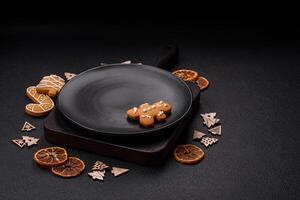 Beautiful festive Christmas composition of an empty plate, gingerbreads and star anise photo