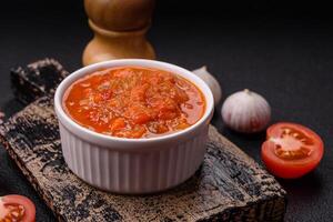 Red hot or spicy sauce with chili peppers, tomatoes, garlic, spices photo