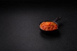 Red hot or spicy sauce with chili peppers, tomatoes, garlic, spices photo