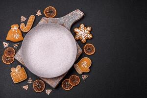 Beautiful festive Christmas composition of an empty plate, gingerbreads and star anise photo