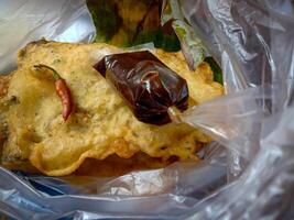 Tempe Mendoan is a traditional food made from tempeh covered in flour batter with a mixture of sliced leeks and spices. cooked by frying. Selective fokus. photo