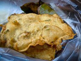 Tempe Mendoan is a traditional food made from tempeh covered in flour batter with a mixture of sliced leeks and spices. cooked by frying. Selective fokus. photo