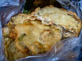 Tempe Mendoan is a traditional food made from tempeh covered in flour batter with a mixture of sliced leeks and spices. cooked by frying. Selective fokus. photo