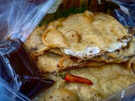 Tempe Mendoan is a traditional food made from tempeh covered in flour batter with a mixture of sliced leeks and spices. cooked by frying. Selective fokus. photo
