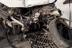Detailed view of damaged car after accident, exposing crushed engine parts, tangled wreckage. Ideal for use in materials related to traffic safety, vehicle insurance, emergency response training. photo