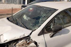 Close-up of car showing extensive front-end damage after collision, highlighting shattered windshield and deformed hood. Perfect for content on road safety, insurance claims, and automotive repairs. photo