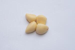 Peeled garlic cloves, fresh and ready for cooking, with a vibrant white color and smooth texture, ideal for culinary uses and food photography. photo
