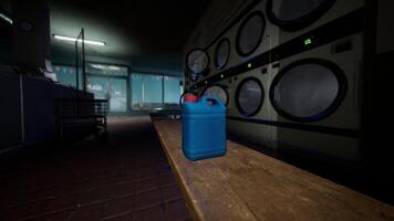 A blue canister on a table in front of a laundromat video