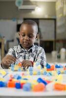 portrait of black little child playing with colored block photo
