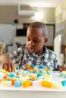 portrait of black little child playing with colored block photo