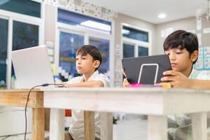 Portrait of latin american children students using a laptops and Digital Tablet in a classroom. photo