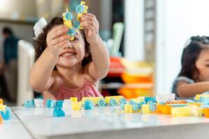 portrait of latin american little child playing with colored block photo