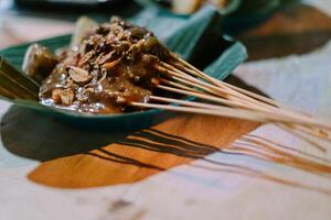 Padang satay skewers, grilled to perfection and served with a rich, spicy sauce, offer a flavorful taste of traditional Indonesian cuisine photo