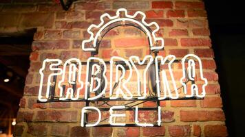 Warsaw, Poland. 9 July 2024. The revitalized Fabryka Norblina is an open, vibrant space, filled with boutiques, shops, unique fashion and gastronomic concepts. Neon sign Fabryka Deli. photo