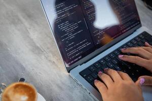 Close-up of a female programmer's hands writing some code, copy space on the left photo