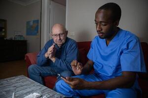 A doctor during a home visit with his patient uses the digital tablet. photo