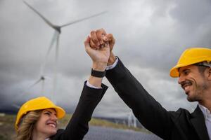 Two engineers celebrate a business success by joining hands in the sky at the photovoltaic power station photo