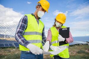 Two colleagues work at a solar power station and analyze a project, cooperation and partnership photo