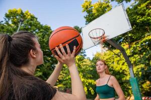 A basketball player is about to shoot and the other girl is defending during a game photo