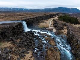 Aerial panorama of Oxarafoss waterfalls in Thingvellir National Park, Iceland, featuring the scenic Oxara River and the unique landscape created by the tectonic plates of America and Eurasia. photo