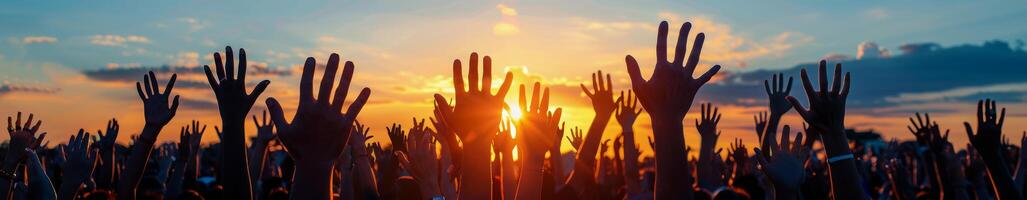 Silhouette of Raised Hands During a Sunset Concert photo