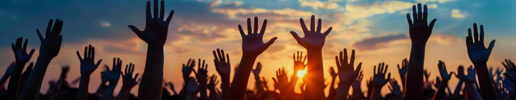 Silhouette of Raised Hands During a Sunset Concert photo