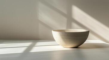 White Ceramic Bowl With Sunlight and Shadows on a White Surface photo