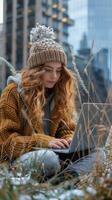 Woman Sitting in Grass Using Laptop photo