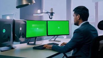 A Man working in front of computer, green screen in office room. video
