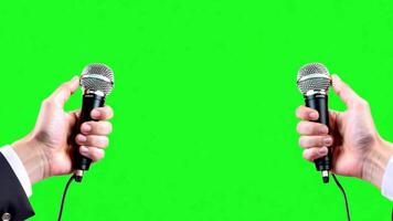 Two hands holding microphone with interview outfit template on looping green screen background. video