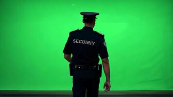 une Sécurité garde dans uniforme, patrouiller un zone. vert écran toile de fond. haute contraste éclairage à souligner le uniforme. video