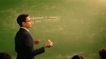 A teacher is writing on the blackboard Studying in class against a green screen backdrop. video