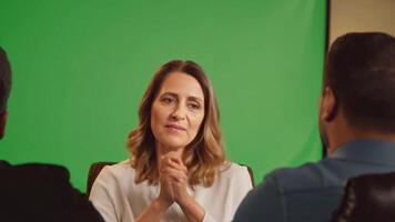 A therapist in a cozy office, listening attentively. Green screen backdrop. Warm, soft lighting to create a welcoming atmosphere. video