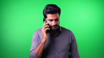 Indian man listening and sending voice message using mobile phone on green screen video