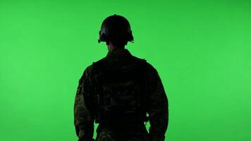 A soldier in uniform, standing at attention. Green screen backdrop. High contrast lighting to emphasize the uniform. video