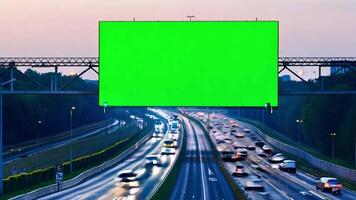 Time-lapse of a green-screen billboard on the side of a freeway with evening traffic. video