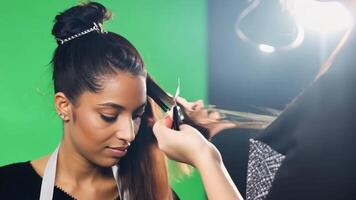 A hairstylist in an apron, cutting hair. Green screen backdrop. Soft, diffused lighting to reflect a salon environment. video