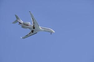 Private jet against the blue sky as it approaches Nice, France photo