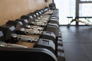 Selective focus on a row of weights in a gym photo