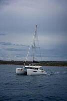 Vela Luka, Croatia - July 4, 2024. Catamaran sailing near Croatia coast. Close-up view of the deck, mast and sails. Yachting concept. High quality photo