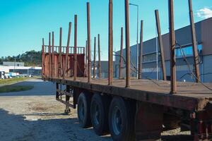 An empty timber truck stands in the middle of the forest. Forestry technologies - timber carrier for transporting logs. photo