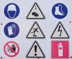 A board with warning signs about danger that stands before the start of construction on the field photo