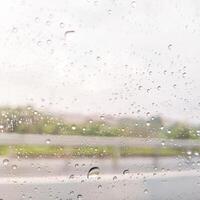 blurry window with dots of rain water for background photo