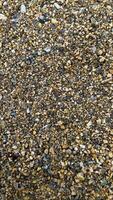 Texture of yellow sand with small pebbles. Sand pattern photo