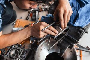 Mechanic is installing a motorcycle piston in garage.Disassembly and maintenance of motorcycle engine photo
