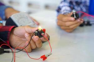 Science classroom, students are conducting experiments on basic electrical circuits. Concept of science classroom, learning science, science skills, learning, science experiments. photo