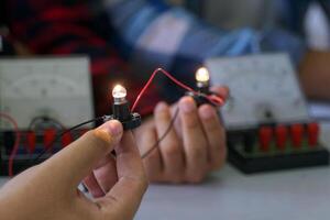 Science classroom, students are conducting experiments on basic electrical circuits. Concept of science classroom, learning science, science, science skills, learning, science experiments. photo