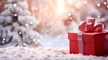 Close up view of red gift box with a shinny red bow on snowflakes with blurry snowy Christmas tree and fresh snow white bokeh lights. holiday or festive greeting card banner. right composition photo