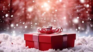 Close up view of center composition red gift box with a shinny red bow on snowflakes with blurry snowy Christmas tree and fresh snow white bokeh lights. holiday or festive greeting card banner. photo